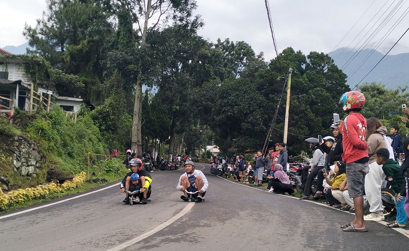 RAMAI: Ratusan peserta Gledekan Tretes bergantian adu cepat menyusuri jalan sejauh 500 meter di tikungan Lingkungan Palembon, Tretes. Kegiatan ini dilakukan setiap Minggu pagi. 