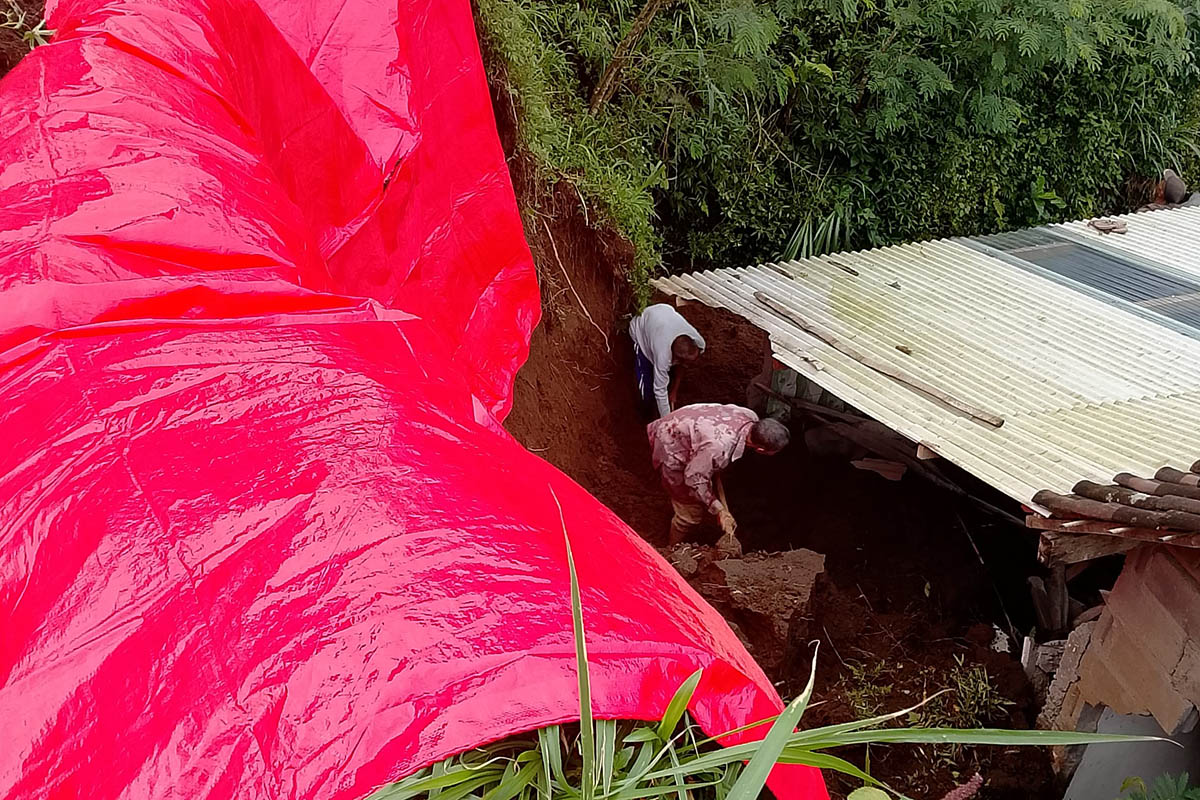 DITUTUPI: Kondisi tebing yang ambrol, ditutupi terpal. Hujan deras yang melanda, membuat tebing setempat ambrol.