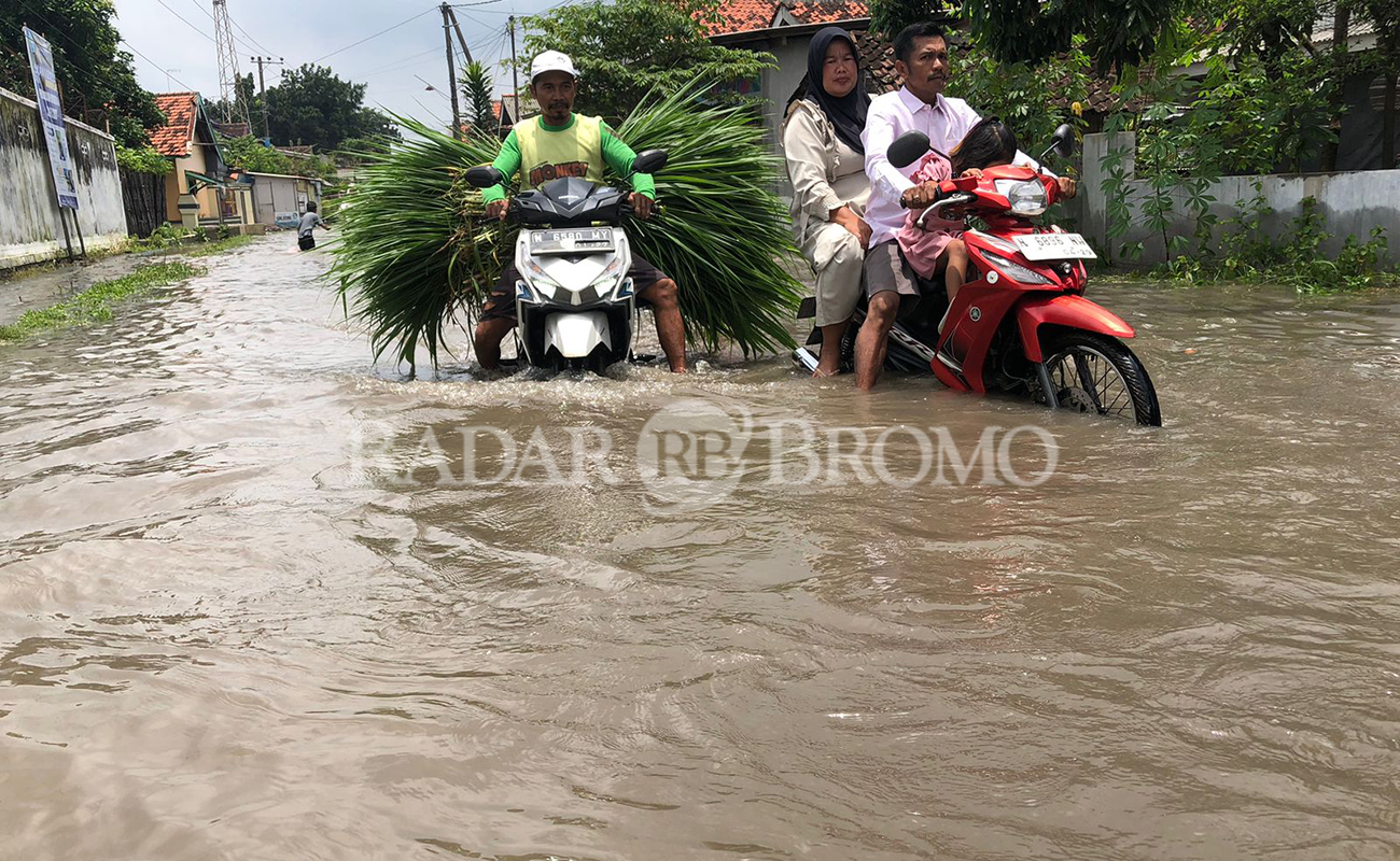 TERJANG BANJIR: Dua motor warga saat melintas di jalanan Desa Sumberkedawung, Kecamatan Leces, Kabupaten Probolinggo, yang terdampak banjir Rabu (4/3) siang.