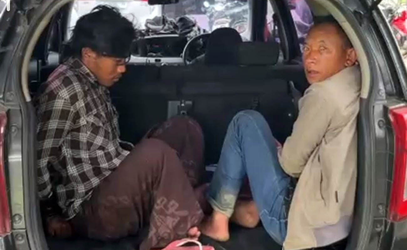TERSANGKA: Dua dari tiga tersangka aksi premanisme pada petani Bromo di Puspo, Kabupaten Pasuruan saat diamankan petugas di Mapolda Jatim. 