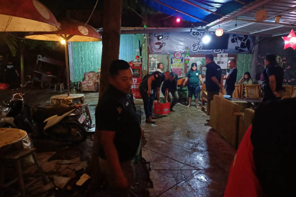TAK PUNYA IZIN: Petugas mengamankan puluhan botol miras di salah satu tempat usaha di Kecamatan Dringu.
