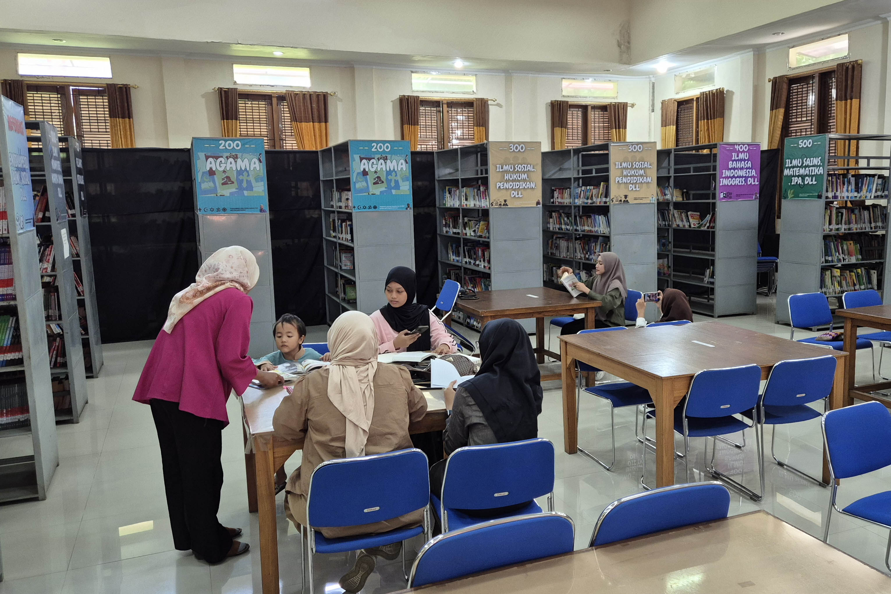 TAMBAH ILMU: Sejumlah warga membaca buku di Perpusda Kota Pasuruan.