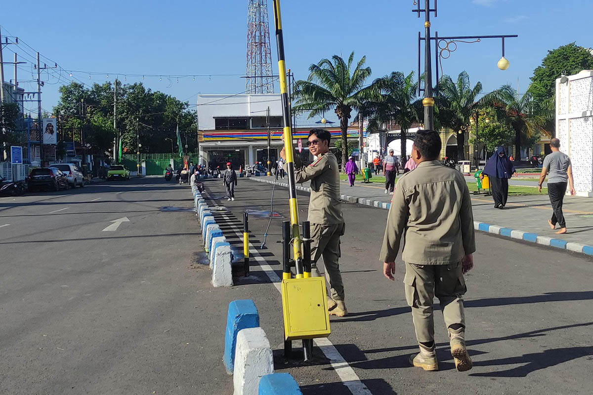 PENGATURAN: Petugas Satpol PP Kota Pasuruan saat memasang portal di area Alun-Alun Kota Pasuruan. Langkah ini dilakukan, untuk mencegah kendaraan masuk ke area alun-alun.