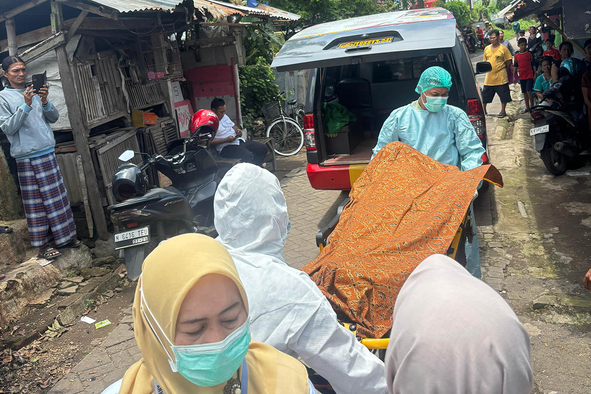 EVAKUASI: Petugas membawa jenazah Kar yang ditemukan tewas dalam kamar indekosnya di Desa/Kecamatan Gempol.
