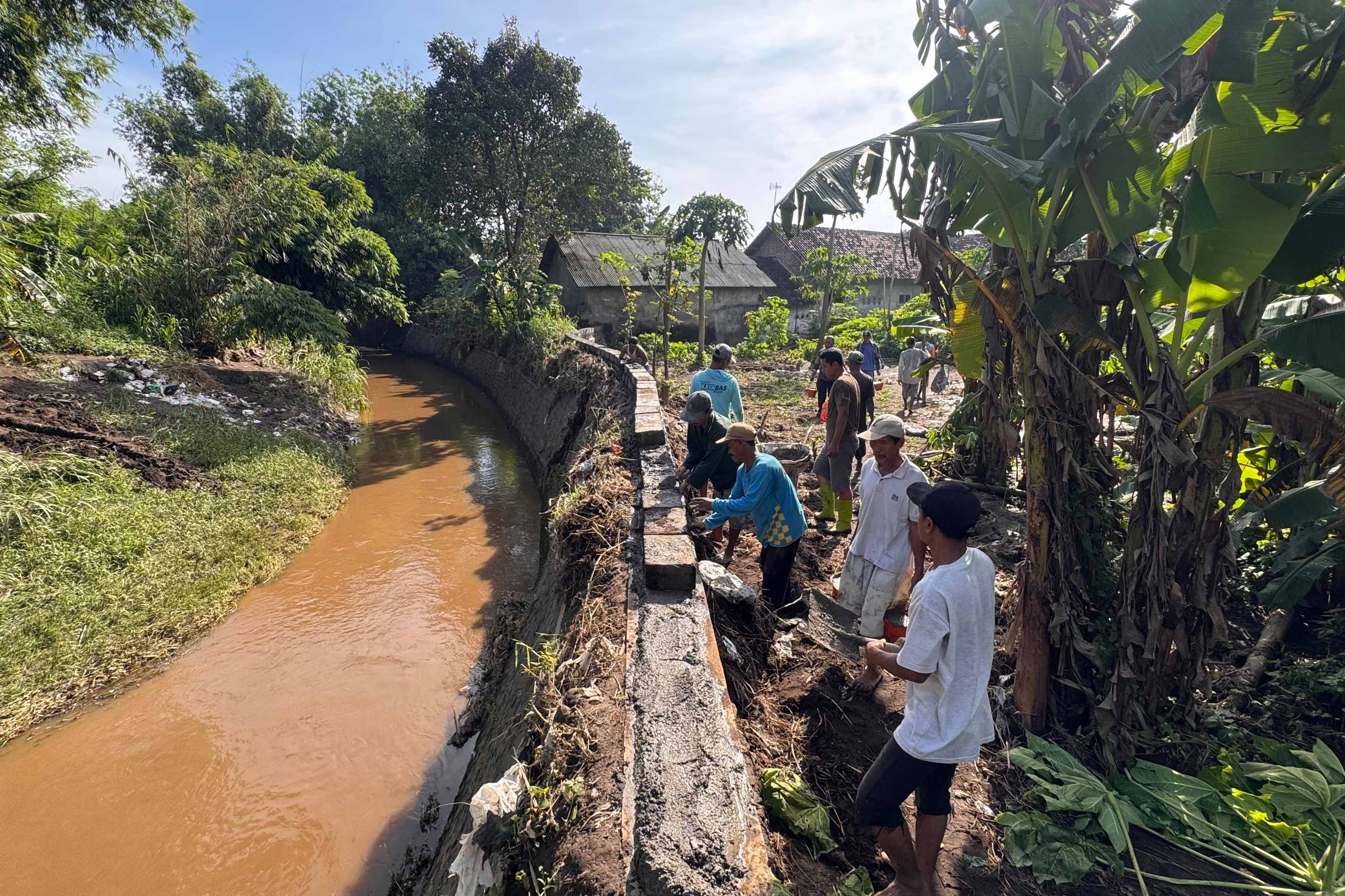 GOTONG ROYONG: Sejumlah warga Desa Tambakrejo, Kecamatan Tongas, memeprbaiki parapet di Dusun Krajan, Jumat (6/3).