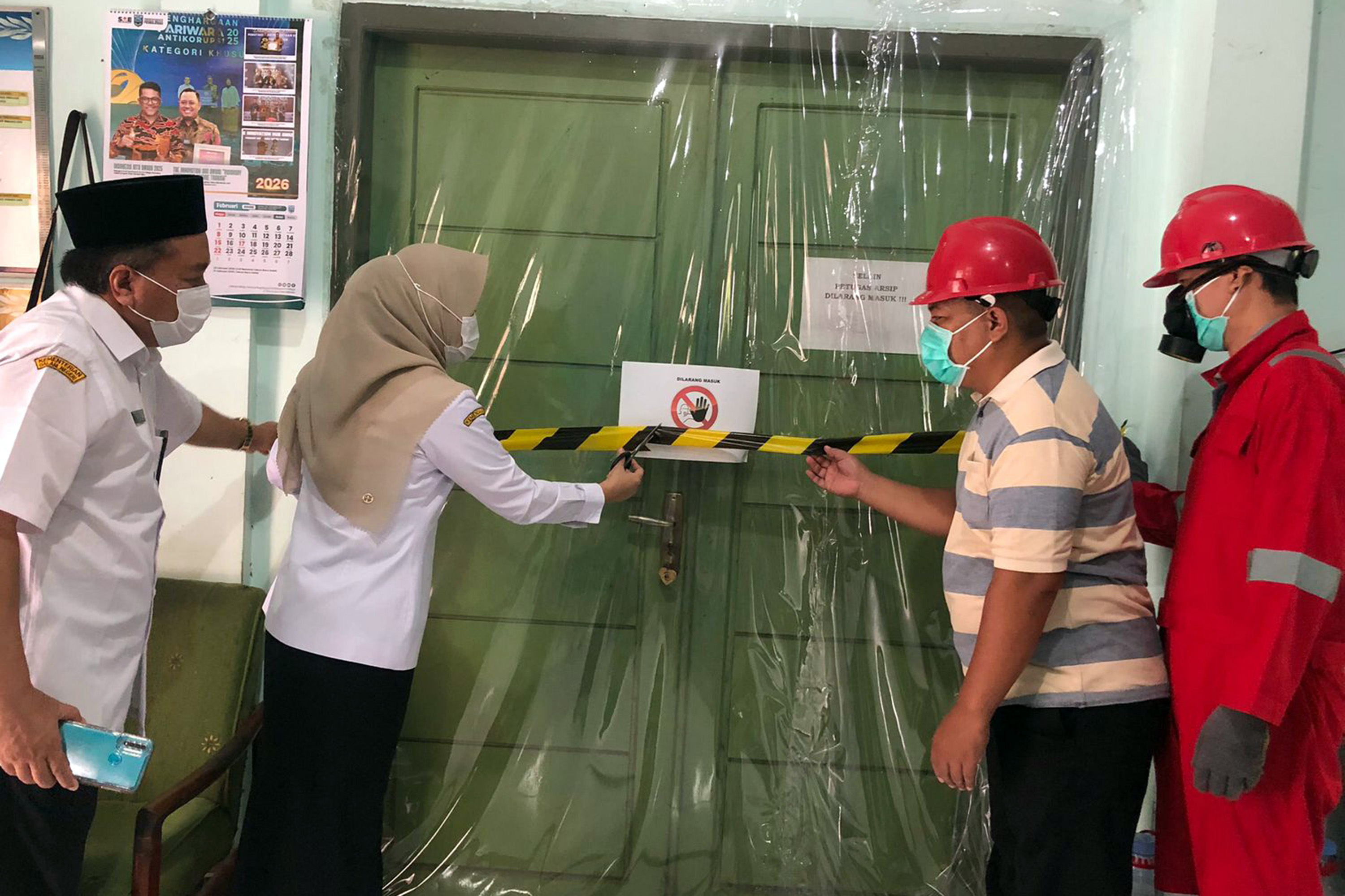FUMIGASI: Kepala Dispersip Kabupaten Probolinggo Ulfiningtyas saat membuka segel pintu Depo Arsip di Jalan Raya Dringu, Kabupaten Probolinggo, Rabu (4/3).