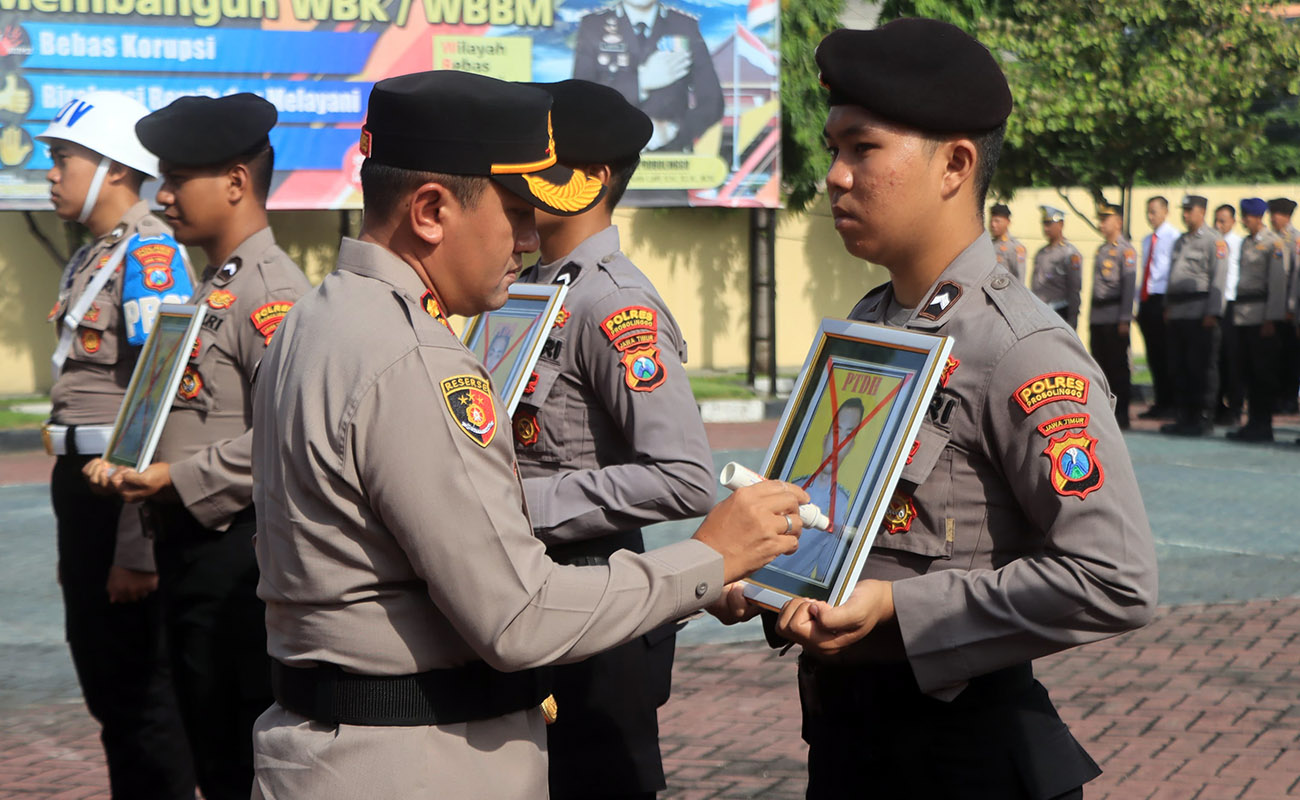 DIPECAT: Kapolres Probolinggo AKBP M. Wahyudin Latif mencoret foto anggota yang disanksi tegas PTDH.