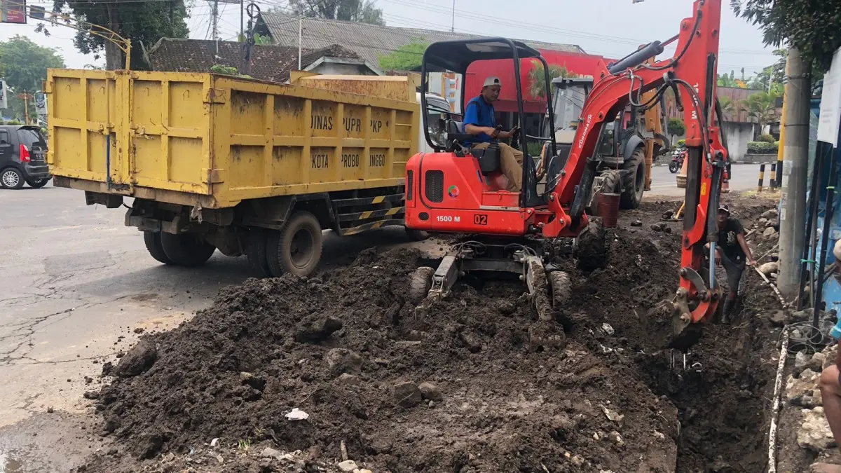KERUK: Pekerja Dinas PUPR PKP Kota Probolinggo melakukan normalisasi drainase di Simpang Empat Randu Pangger, Kota Probolinggo, beberapa waktu lalu. INNEKE AGUSTIN/JAWA POS RADAR BROMO