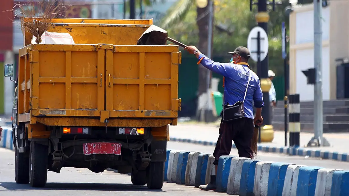 BUANG: Petugas kebersihan Kota Pasuruan saat membersihkan sampah di jalanan. Selama Ramadan, produksi sampah cenderung meningkat. (Dokumen Radar Bromo)