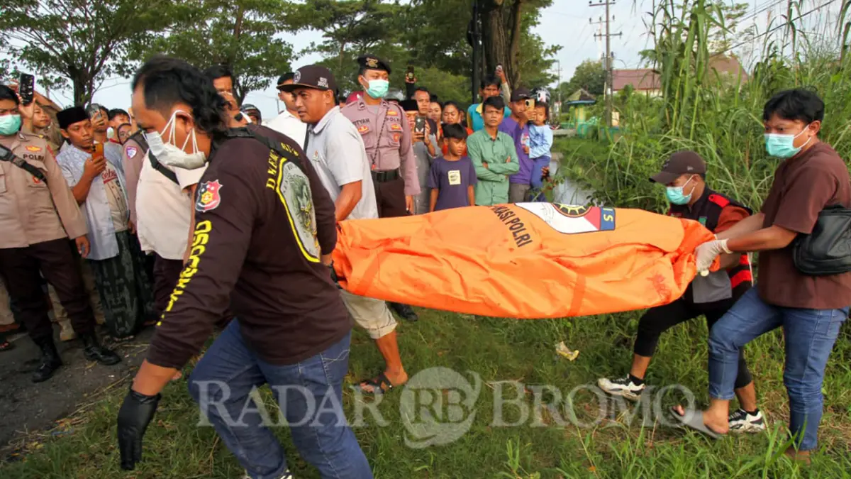 Petugas dibantu warga saat mengevakuasi jenazah Mrs X yang ditemukan di bawah menara tower Rejoso, Kabupaten Pasuruan, Senin (23/3). (Mokhamad Zubaidillah/ Radar Bromo)
