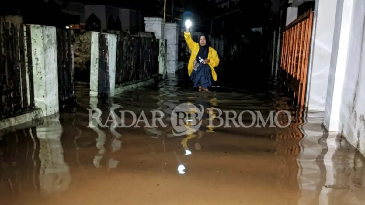 SEBELUM SURUT: Warga di Kota Pasuruan menerjang genangan sembari membawa senter. (Foto: M Zubaidillah/Jawa Pos Radar Bromo)