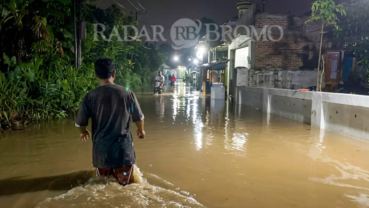 Seorang warga menerjang banjir yang merendam kawasan Winongan, Kabupaten Pasuruan (24/3). (Mokhamad Zubaidillah/ Radar Bromo)