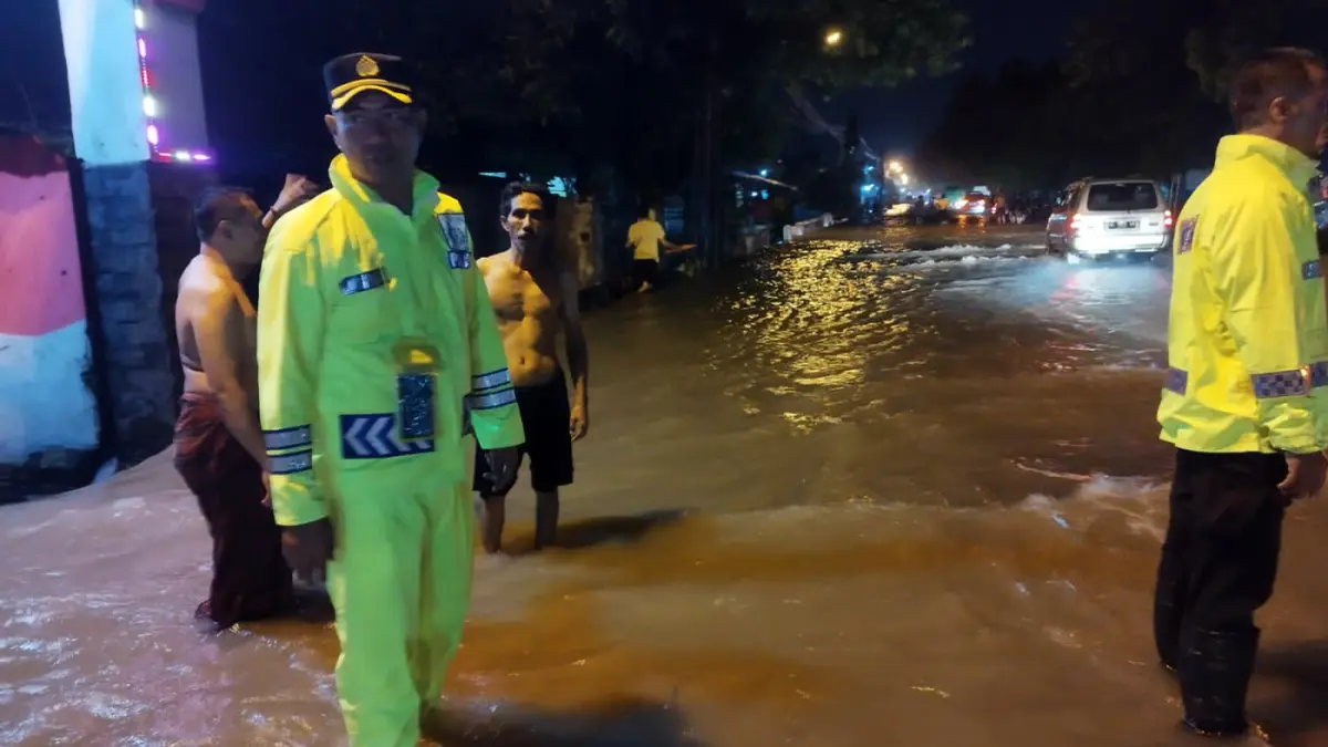 Petugas kepolisian saat memantau banjir yang merendam pantura, Rabu (24/3) malam. 