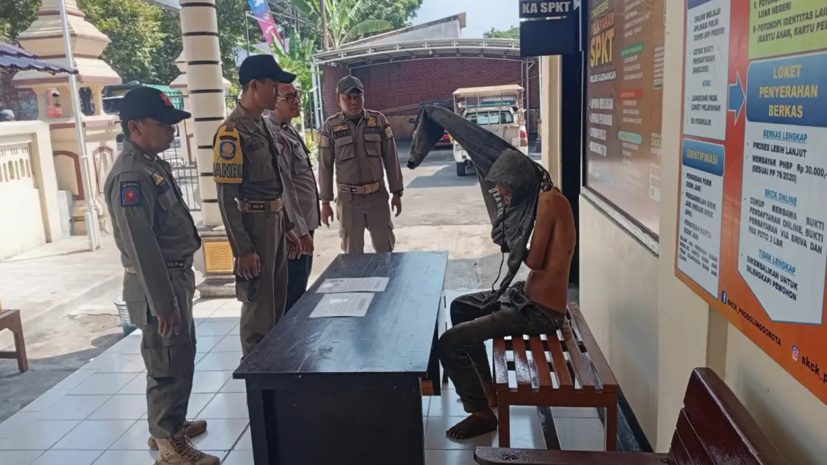 DIAMANKAN: Anggota Satpol PP Kota Probolinggo menjemput pria tanpa identitas di Mapolsek Kademangan, Minggu (29/3). (SATPOL PP KOTA PROBOLINGGO for Jawa Pos Radar Bromo)
