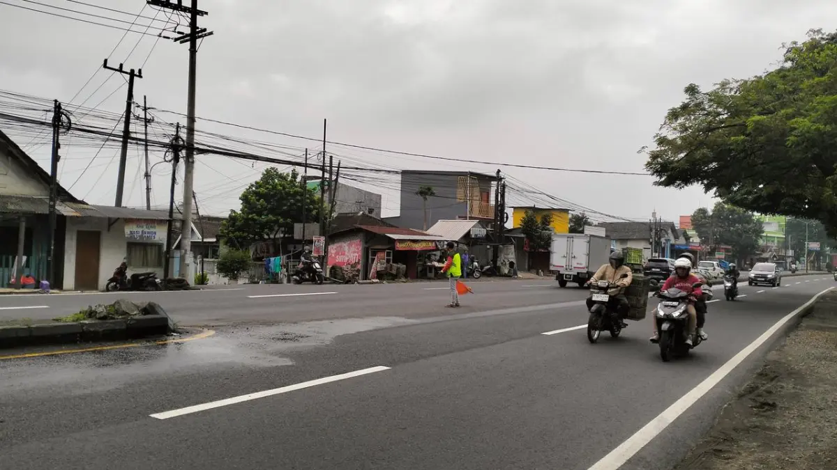 JALUR NASIONAL: Sejumlah pengendara melintas di jalan nasional Simpang Tiga Suwayuwo, Kecamatan Sukorejo, yang langganan banjir ketika hujan lebat. (RIZAL FAHMI SYATORI/JAWA POS RADAR BROMO)
