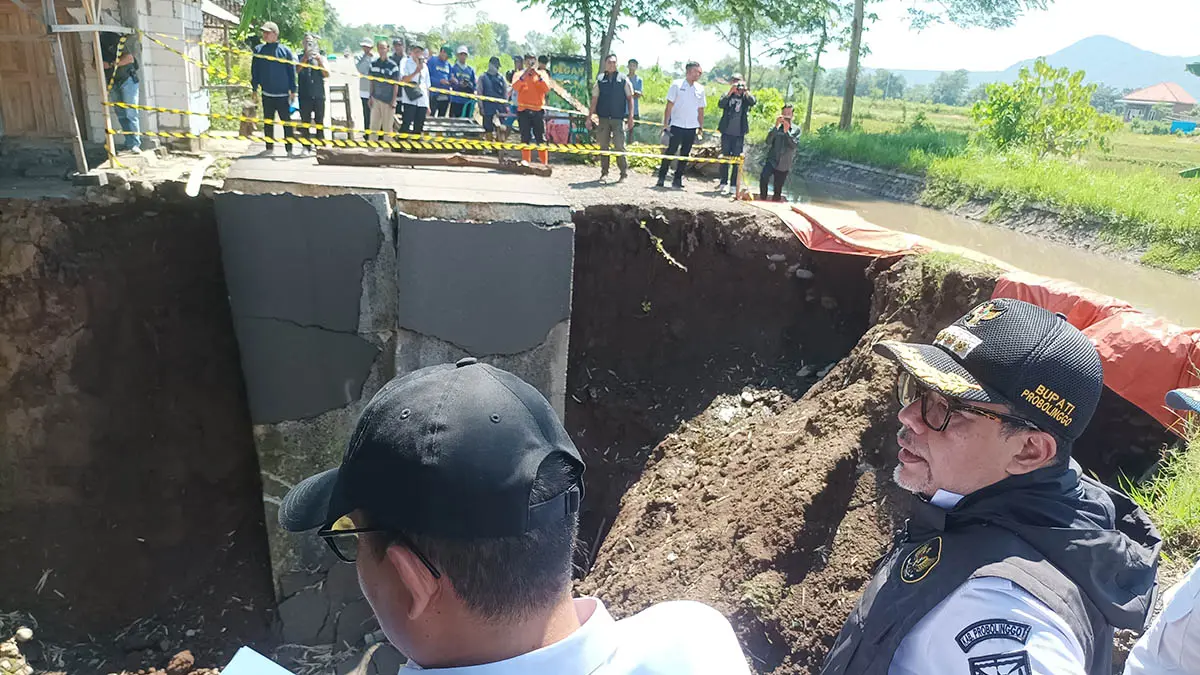 PENGHUBUNG ANTARKECAMATAN: Bupati Probolinggo Mohammad Haris (berompi) meninjau jalan ambruk di Desa Sumbercenteng, Kecamatan Kota Anyar, pagi kemarin (1/4). (Agus Faiz Musleh/Jawa Pos Radar Bromo)