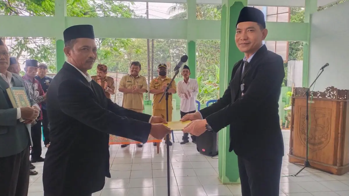 TERISI: Camat Gading Erwin Yulianto (kanan) menyerahkan SK Bupati Probolinggo ke Pj Kepala Desa Bulupandak Abdussalam. (Istimewa)