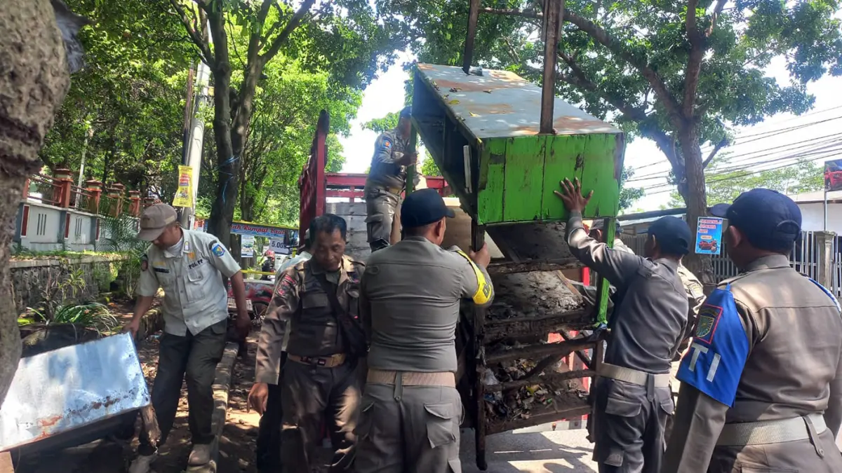 PENERTIBAN: Sejumlah anggota Satpol PP Kota Probolinggo membongkar lapak PKL di Jalan Mastrip, Kota Probolinggo, Kamis (2/4). (Inneke Agustin/ Radar Bromo)