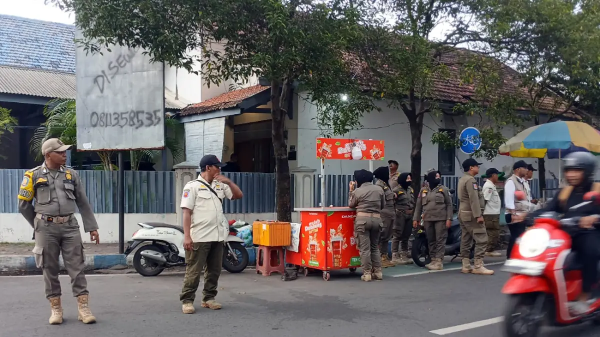 DITERTIBKAN: Sejumlah petugas Satpol PP Kota Probolinggo menertibkan PKL yang berjualan di sisi timur Alun-Alun Kota Probolinggo, Jalan Ahmad Yani, Kamis (2/4) sore.