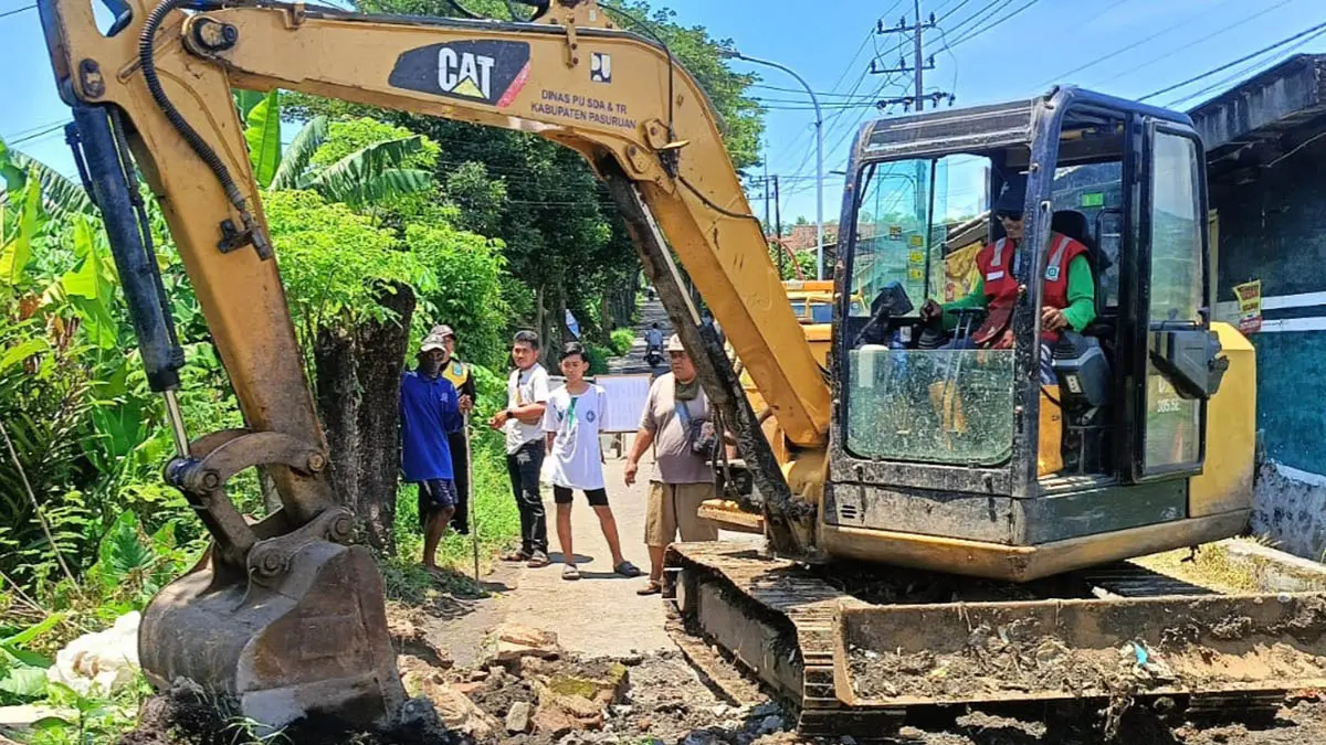 JALAN KABUPATEN: Alat berat yang dikerahkan untuk membongkar gorong-gorong ambrol di Desa Kepulungan, Kecamatan Gempol. (Rizal F SYatori/Jawa Pos Radar Bromo)