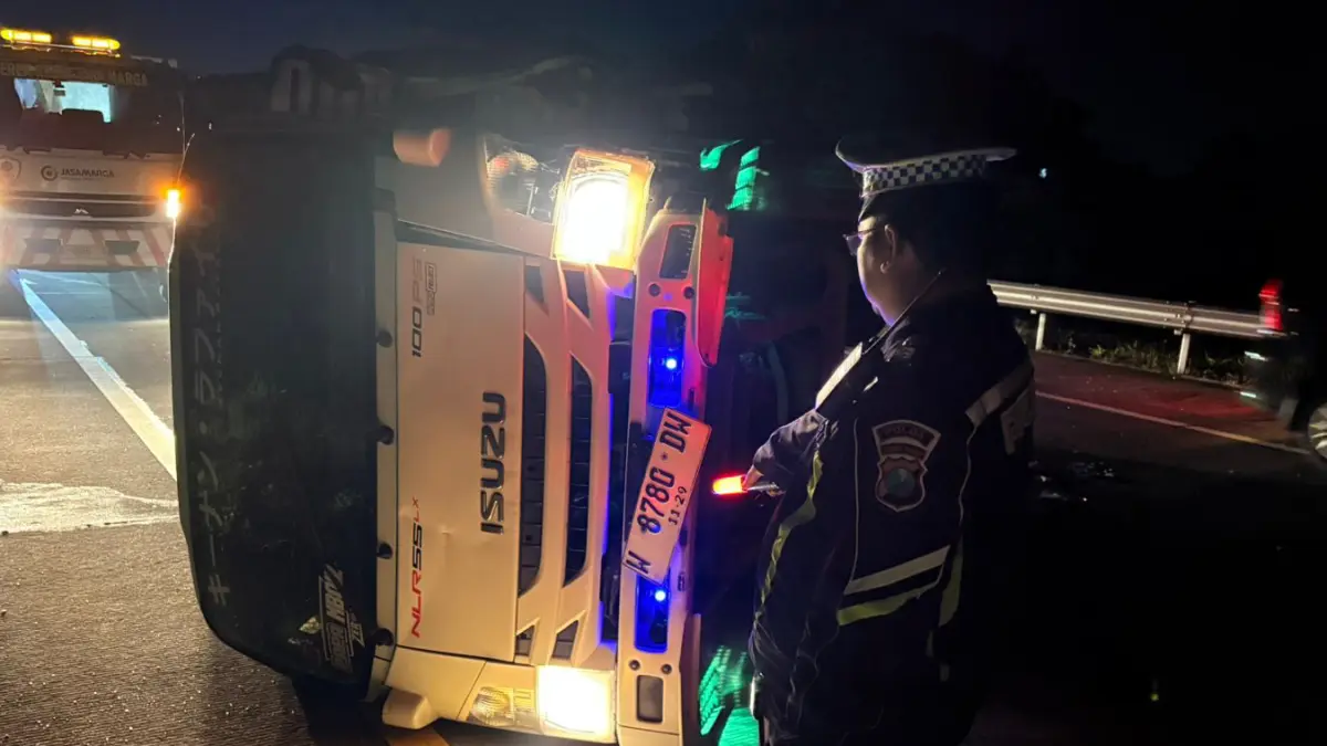 TERGULING: Truk yang dikemudikan Sugianto terguling di Km 788 Jalur A Tol Gempol-Pasuruan, Senin (6/4). (PJR DITLANTAS POLDA JATIM FOR JAWA POS RADAR BROMO)