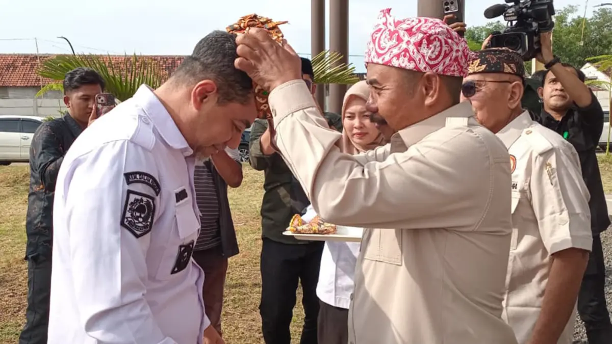 KEARIFAN LOKAL: Ketua PKDI Kabupaten Probolinggo Sanemo memasangkan udeng khas Kabupaten Probolinggo kepada Bupati Probolinggo dr. Mohammad Haris.