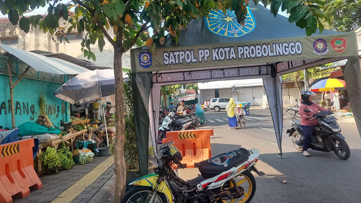 POS TAK DIGUBRIS: Sejumlah pedagang berjualan di area trotoar persis di belakang pos Satpol PP di Jalan Cut Nyak Dien, Kota Probolinggo. (Arif Mashudi/ Radar Bromo) 