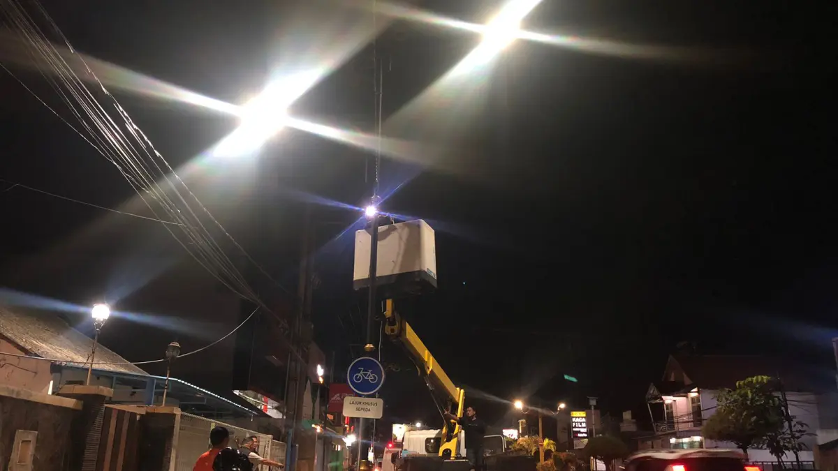 DIKEBUT: Petugas Dishub Kota Probolinggo saat melakukan penarikan kabel untuk menyalakan lampu PJU di Jalan Soekarno Hatta, Selasa (7/4). (INNEKE AGUSTIN/JAWA POS RADAR BROMO)