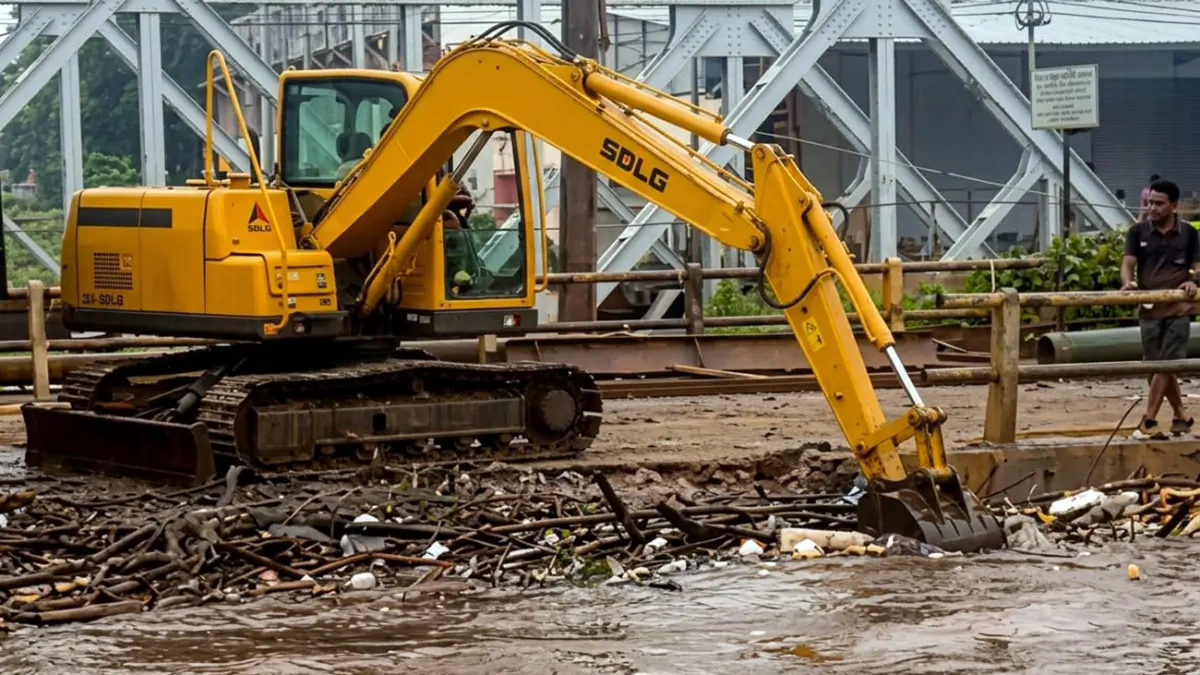 Alat berat dikerahkan untuk mengevakuasi sampah yang tersangkut di jembatan Bok Wedi Blandongan, Pasuruan. (Mokhamad Zubaidillah/ Radar Bromo)