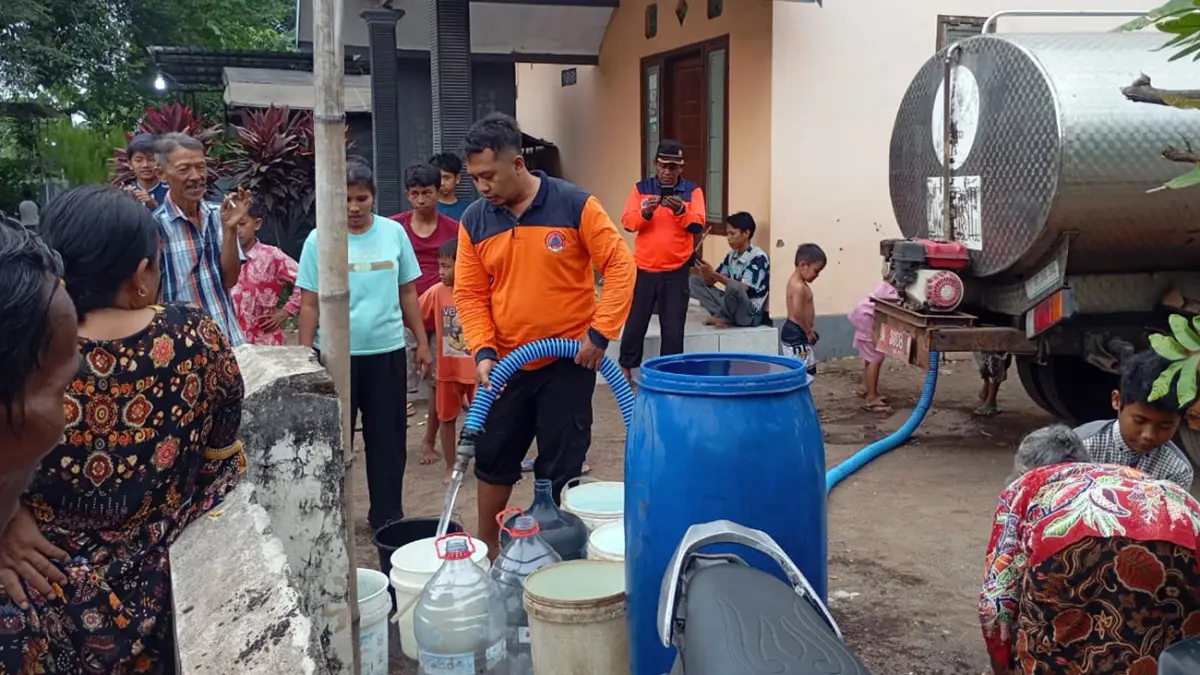 DISTRIBUSI: Petugas BPBD Jawa Timur saat mendistribusikan 12.000 liter air bersih di Dusun Krajan, Desa Liprak Kidul, Kecamatan Banyuanyar, Kabupaten Probolinggo.