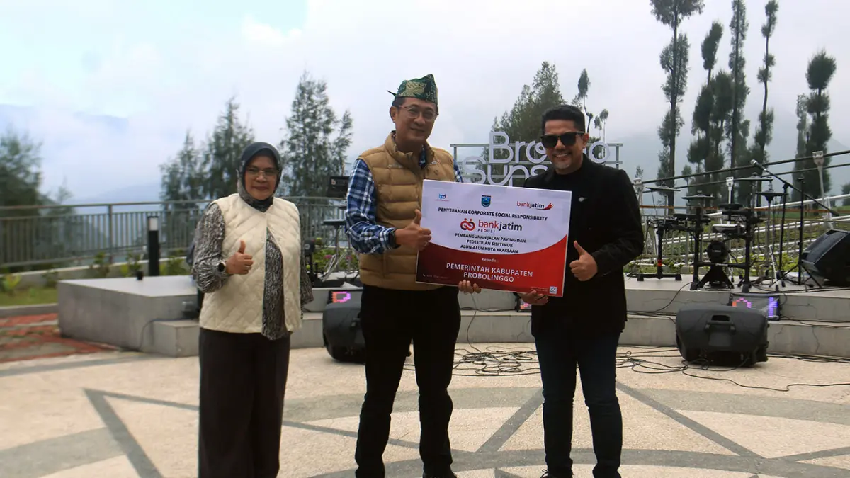 SIMBOLIS: Direktur Keuangan, Treasury & Global Services Bank Jatim RM Wahyukusumo Wisnubroto secara simbolis menyerahkan CSR hasil pembangunan jalan paving kepada Bupati Probolinggo dr. Mohammad Haris didampingi Pemimpin Cabang Kraksaan Siska Dian Permatasari. (Jamaludin/ Radar Bromo)