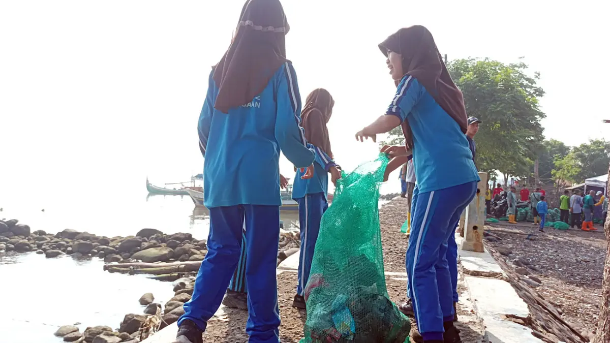 Sejumlah siswi ikut bersih-bersih sampah kawasan Kalibuntu, Kraksaan, Probolinggo. (Agus Faiz Musleh/ Radar Bromo)