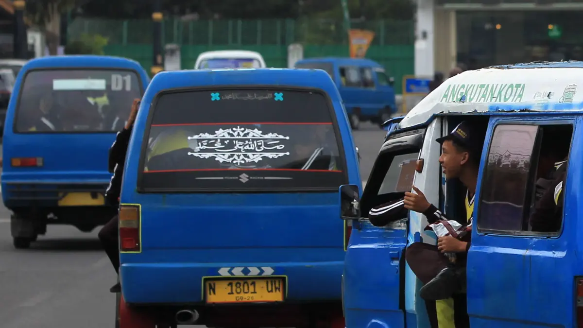 MASIH BERTAHAN: Angkot di Kota Pasuruan yang mengangkut penumpang melintas di Alun-alun. (Foto: Mokhammad Zubaidillah/Jawa Pos Radar Bromo)