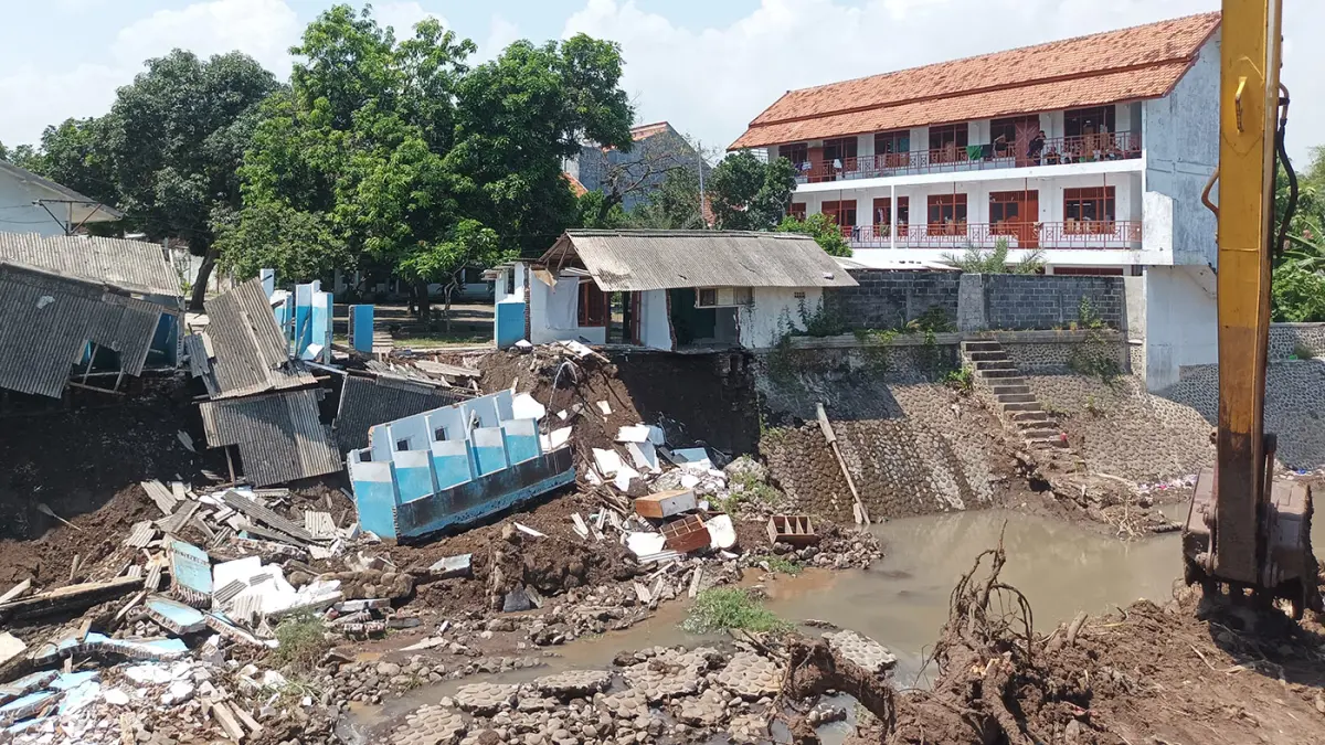 AMBROL: Terlihat bangunan di Pondok Pesantren Syekh Abdul Qodir Al Jaelani (SAQO), Rangkang, Kraksaan, ambrol ke Sungai Ketosono, Kamis (16/4) pagi. (Agus Faiz Musleh/ Radar Bromo)