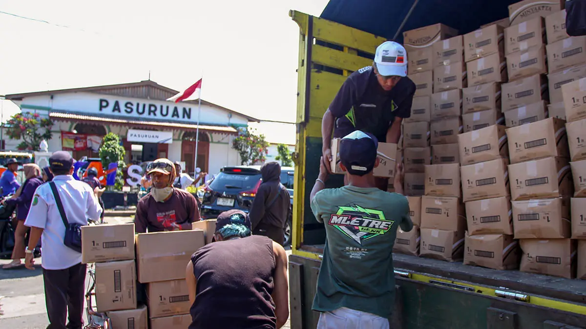 ANGKUT: Sejumlah pedagang saat mengangkut boks-boks Minyakita dari truk. Pemkot mewanti-wanti, agar minyak goreng subsidi itu, dijual sesuai HET. (Mokhamad Zubaidillah/Radar Bromo)