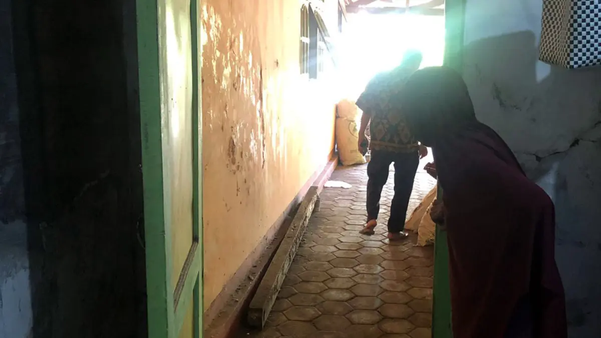 DIBOBOL: Fitri Nabila, 30, saat menunjukkan pintu garasi rumahnya yang rusak akibat dibobol maling pada Kamis (16/4). Motor Beat miliknya amblas digondol pelaku. (Inneke Agustin/ Radar Bromo)