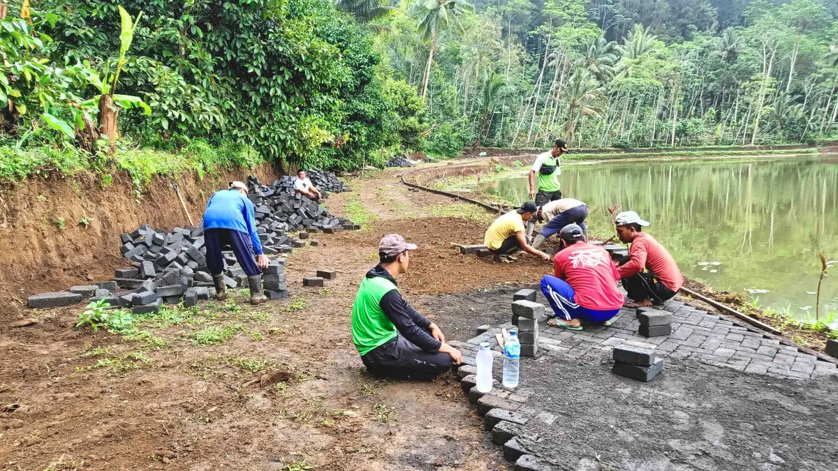 LEBIH BAIK: Pekerja mempaving jalan di RT 4/RW 1, Dusun Krajan. Kini Pemerintah Desa Andungsari berencana membangun TPT di RT 12/RW 4, Dusun Paleran. (Pemdes Andungsari For Jawa Pos Radar Bromo)
