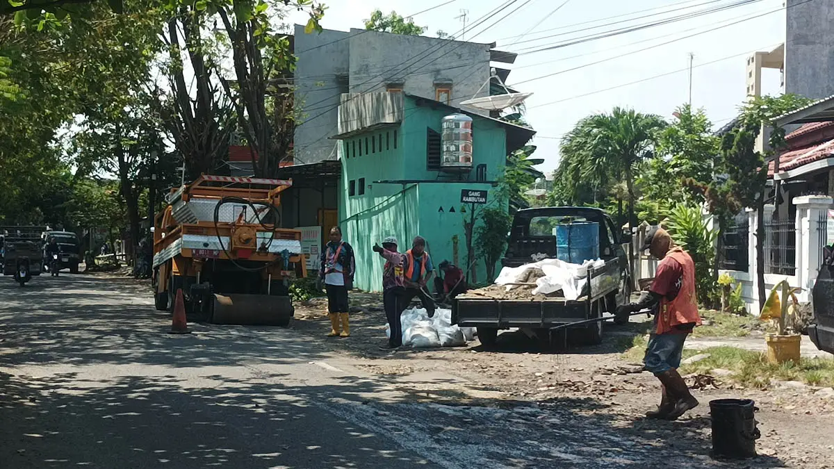 PERBAIKI: Tim truck alpomain membenahi ruas jalan RA Kartini Kraksan, Kamis (16/4). (Foto: Agus faiz musleh/Jawa Pos Radar Bromo)