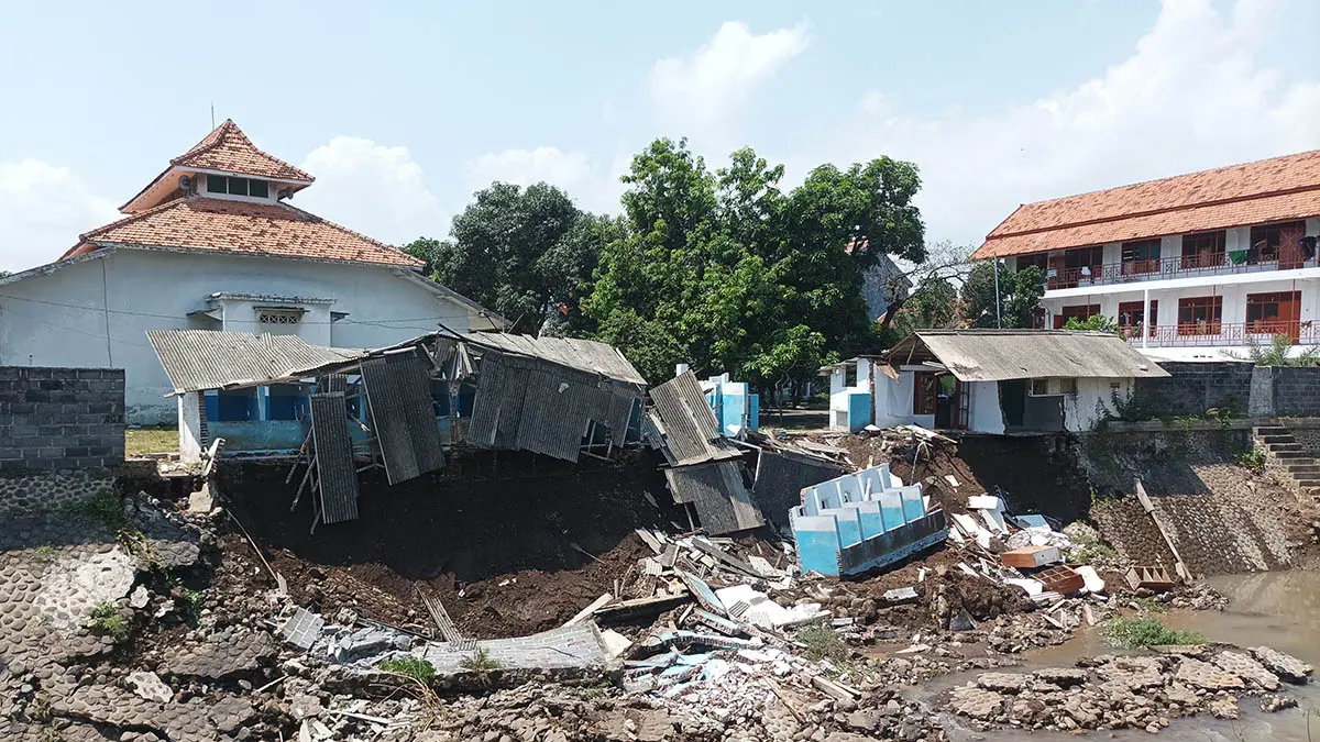 AMBROL: Tebing Sungai Kertosono di area pesantren SAQA Kraksaan yang ambrol, Kamis (16/4) lalu. (Foto: Agus faiz Musleh/Jawa Pos Radar Bromo)
