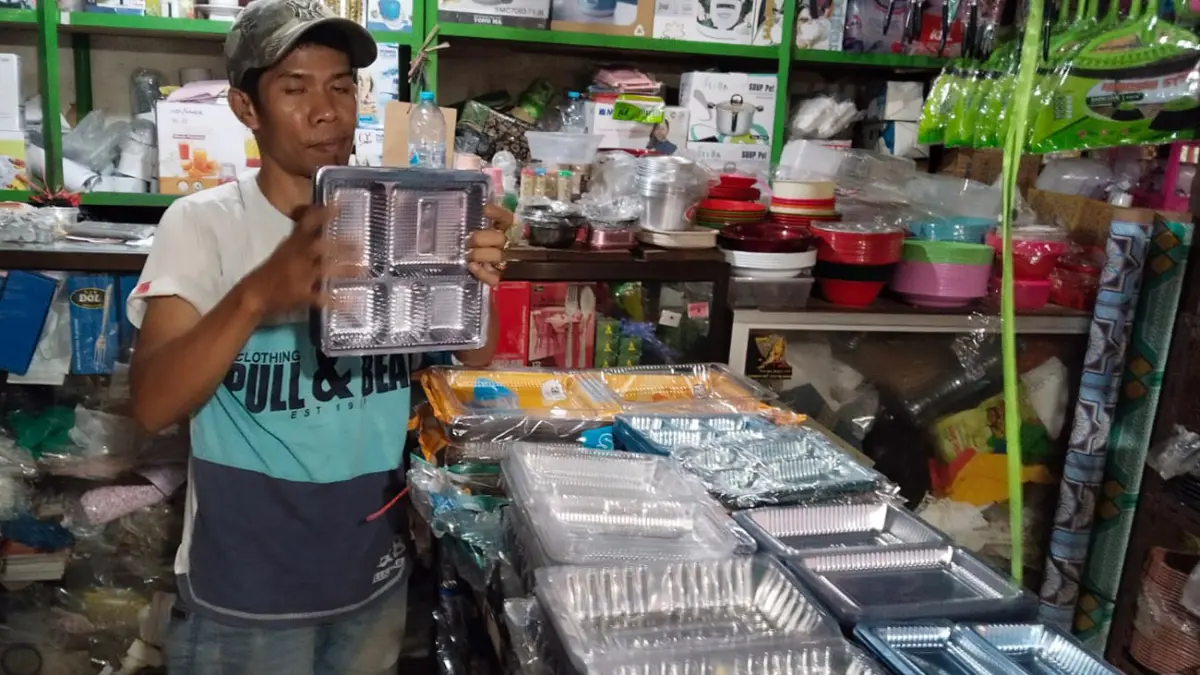 HARGA NAIK: Imron, salah satu pedagang di Pasar Bangil, Kecamatan Bangil, Kabupaten Pasuruan, menunjukkan salah satu jenis plastik yang harganya naik. 