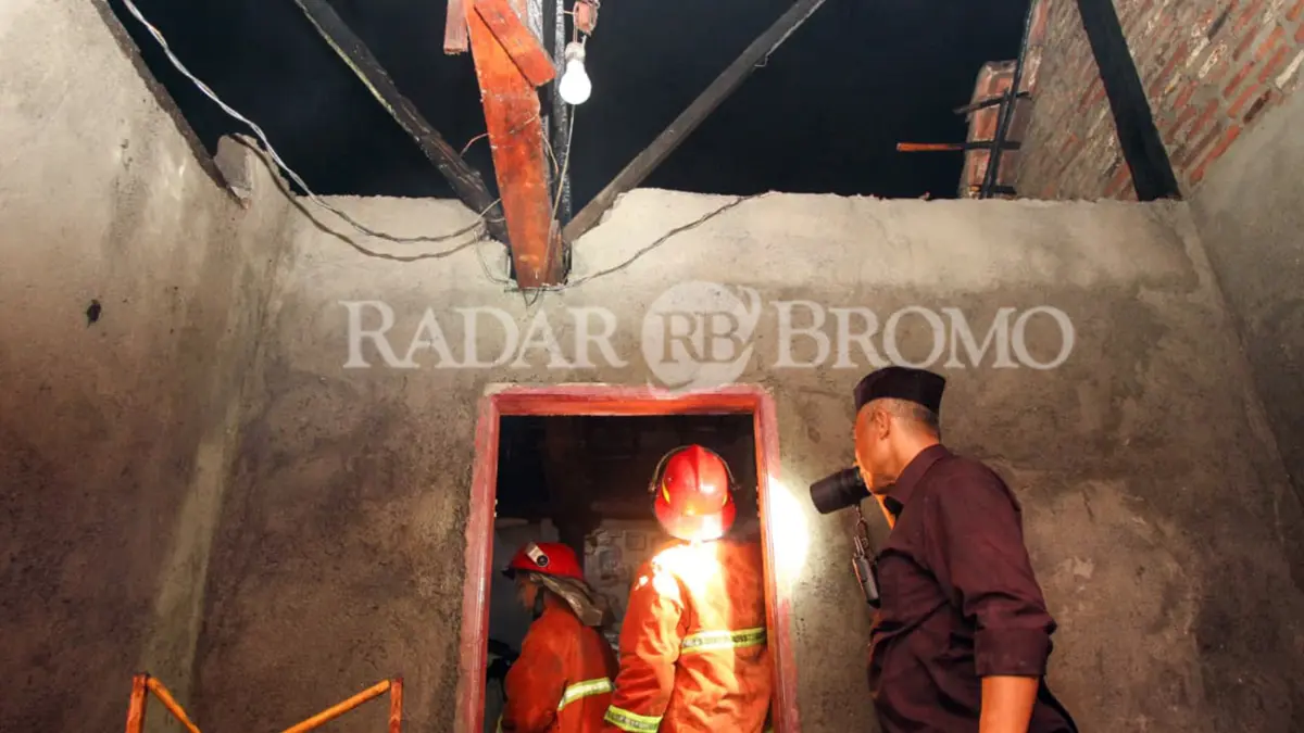 AMUK SI JAGO MERAH: Petugas kepolisian dan damkar saat melakukan pengecekan pada rumah nenek Siti Amanah yang terbakar, Senin malam (20/4). (Mokhamad Zubaidillah/ Radar Bromo)