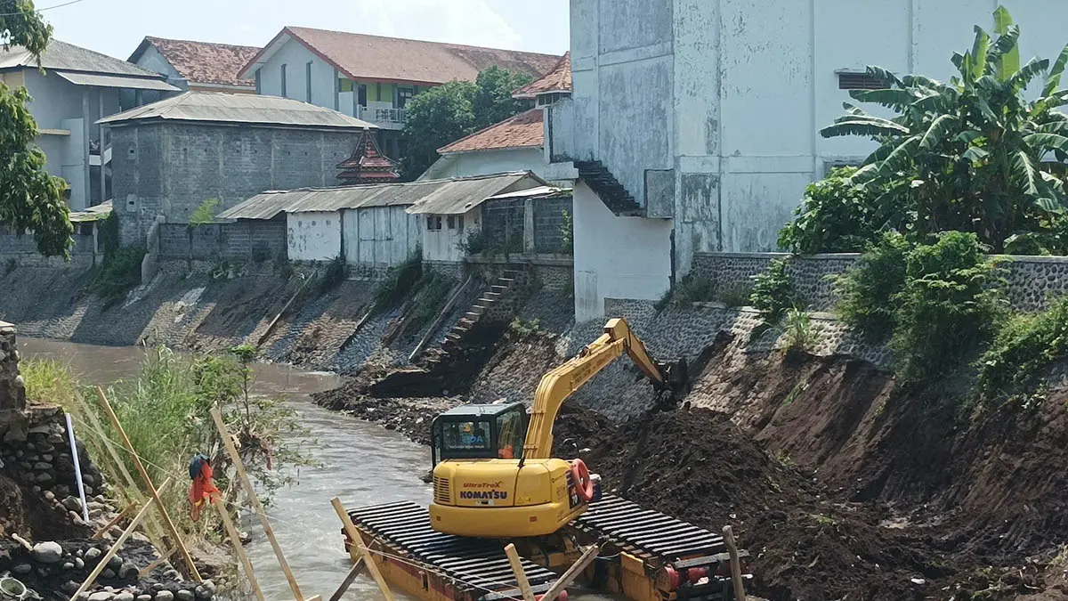 HATI-HATI: Ekskavator amfibi saat melakukan penanganan di Sungai Kertosono belakang pesantren Saqa, Kraksaan. (Foto: Agus Faiz Musleh/Jawa Pos Radar Bromo)