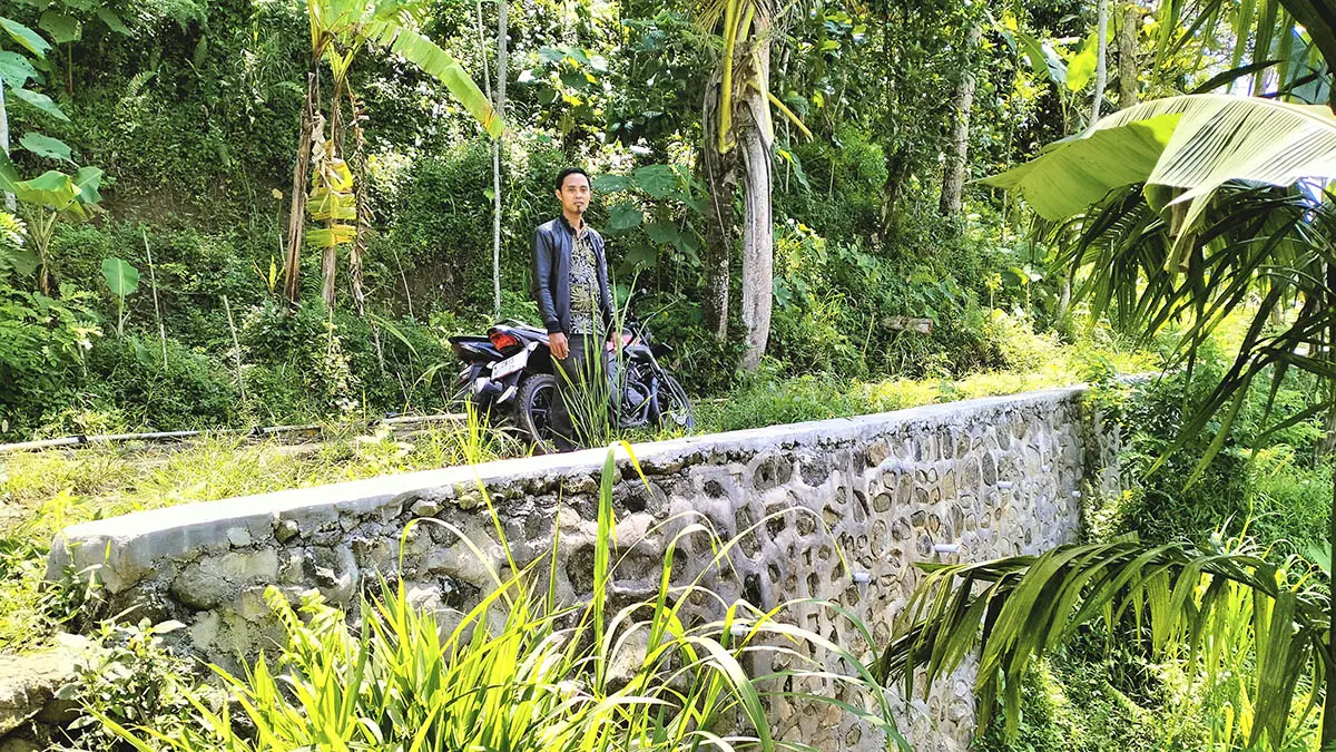 KOKOH: Kepala Dusun Buntoh Imam Hambali mengecek kondisi TPT di RT 11/RW 4, Dusun Curahlengkong. (Foto: Achmad Arianto/Jawa Pos Radar Bromo)