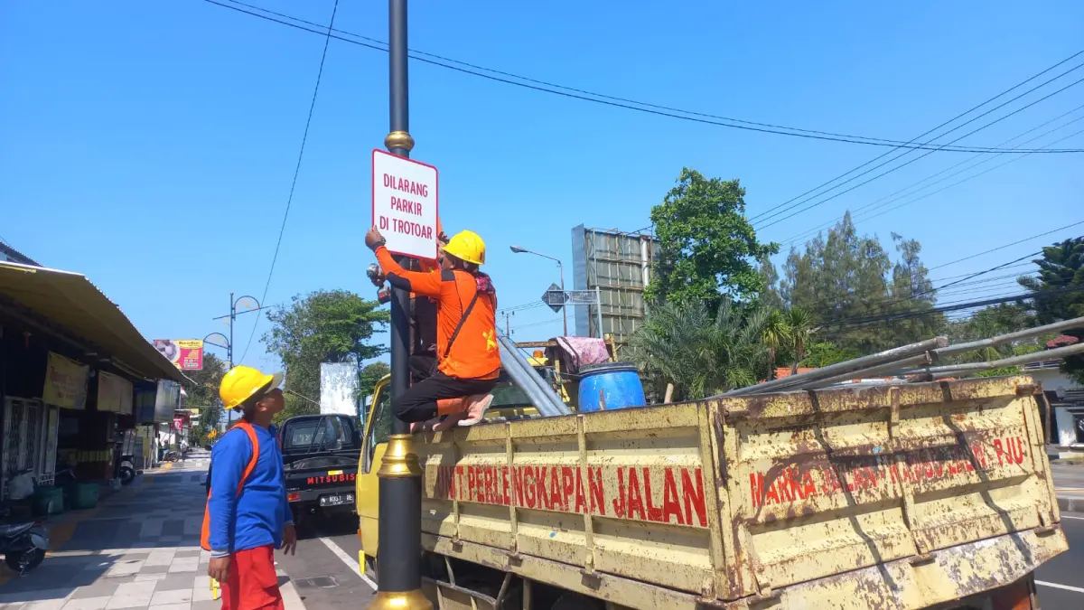 PASANG: Petugas Dishub Kota Probolinggo memasang rambu larangan parkir di trotoar di Jalan Soekarno Hatta, Kota Probolinggo, Senin (20/4). (INNEKE AGUSTIN/JAWA POS RADAR BROMO)