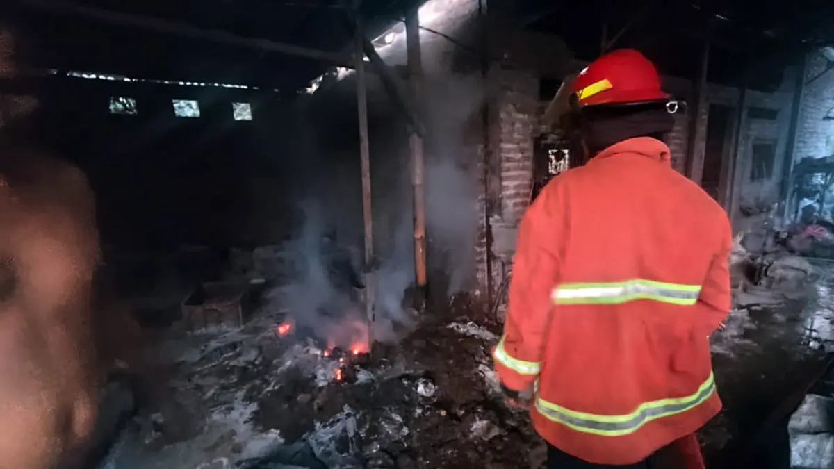 Petugas damkar saat melakukan pembasahan gudang sparepart motor di Jogorepuh, Pasrepan yang terbakar, Senin sore (20/4). 