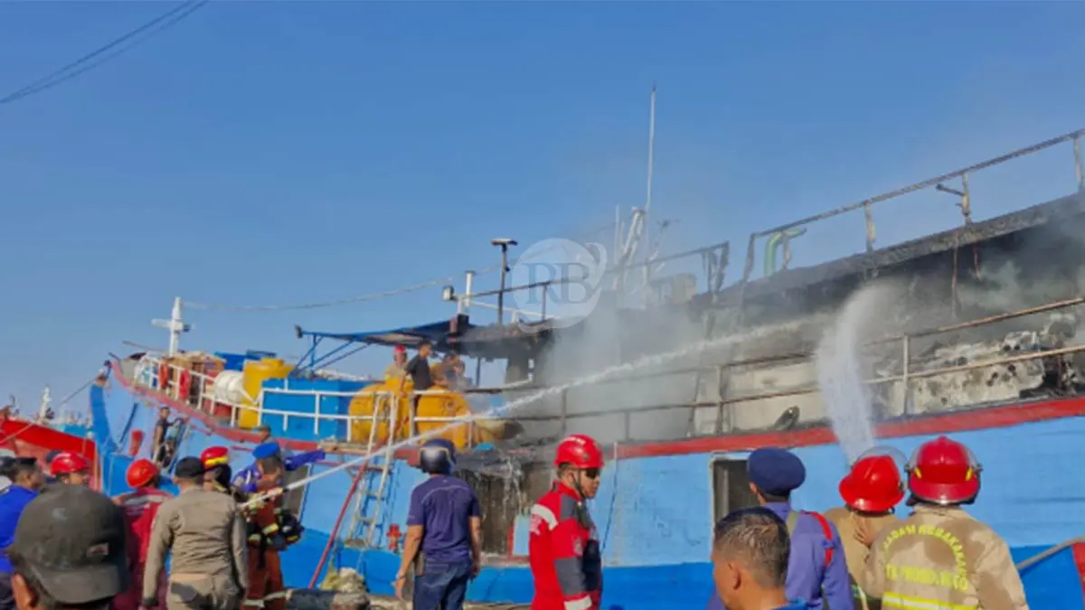 SEMPROT: Petugas Damkar Kota Probolinggo bersama para nelayan melakukan pemadaman pada KM. Gracias di Pelabuhan Perikanan Pantas (PPP) Mayangan, Kota Probolinggo, Senin (20/4) sore. (Foto: Inneke Agustin/Jawa Pos Radar Bromo)