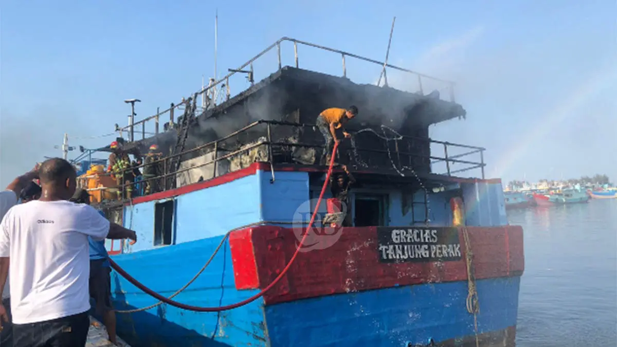 SEMPROT: Petugas Damkar Kota Probolinggo bersama para nelayan melakukan pemadaman pada KM. Gracias di Pelabuhan Perikanan Pantas (PPP) Mayangan, Kota Probolinggo, Senin (20/4) sore. (Foto: Inneke Agustin/Jawa Pos Radar Bromo)