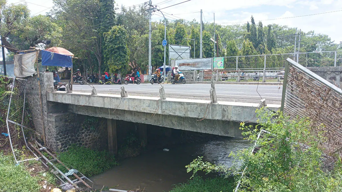 ROBOH: Pagar penahan sampah yang berada di atas jembatan di badan Sungai Kelurahan Kraksaan wetan, Kraksaan. (Foto: Agus Faiz Musleh/Jawa Pos Radar Bromo)