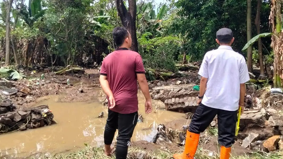 SIAGA: Petugas saat meninjau tanggul yang jebol di wilayah Pohjentrek. Kondisi itu, memberi ancaman terhadap luberan air Sungai Welang. (BPBD Kabupaten Pasuruan)