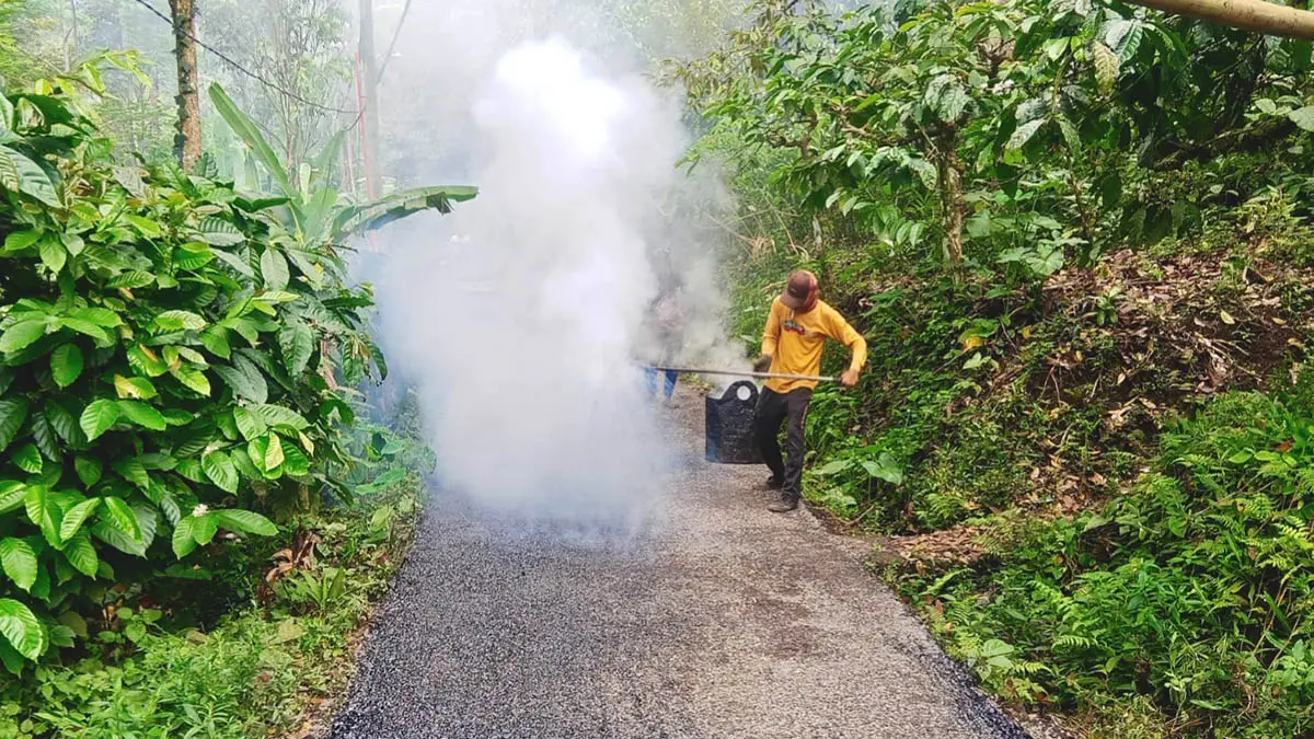 LEBIH NYAMAN: Pekerja sedang melaksanakan pengaspalan jalan di RT 5-6/RW 3, Dusun Kemirian Utara. Pembangunan infrastruktur masih menjadi prioritas Pemerintah Desa Tlogoargo. (Foto : Achmad Arianto/Jawa Pos Radar Bromo)